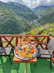 uma bandeja de comida numa mesa com montanhas ao fundo em Zifona Bungalov em Çamlıhemşin