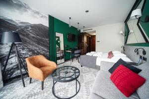ein Hotelzimmer mit einem Bett und einer Couch in der Unterkunft Rysy Boutique Hotel in Zakopane