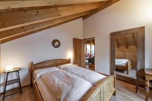 Un dormitorio con una cama grande en una habitación con techos de madera. en Chalcherin - Celerina, en Celerina