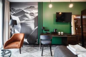 a bedroom with a desk and a tv on a green wall at Rysy Boutique Hotel in Zakopane