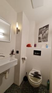 a white bathroom with a sink and a toilet at Design Ferienwohnung 2. Reihe Wörthsee mit Garten und großer Terrasse in Inning am Ammersee