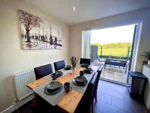 レスターにあるComfy Casa - Syster Properties Serviced Accommodation Leicester Families, Work, Groups - Sleeps 13のダイニングルーム(木製テーブル、椅子付)