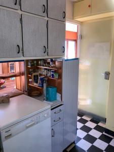 a kitchen with white cabinets and a checkered floor at Chambre privée dans Maison Familiale in Veyrier-du-Lac