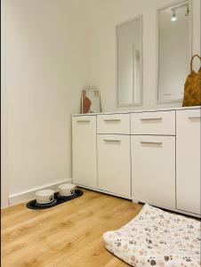 eine weiße Küche mit weißen Schränken und einem Teppich in der Unterkunft Appartement 202 in Klagenfurt am Wörthersee