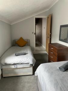 a bedroom with two beds and a dresser and a mirror at Eva Suites in Gillingham