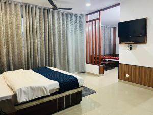 达兰萨拉HOTEL DEVDAR RESORT的一间带床和平板电视的卧室
