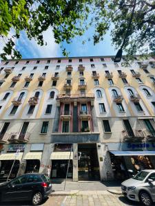 un grande edificio con macchine parcheggiate di fronte di Biloba - Boutique Apartment a Milano