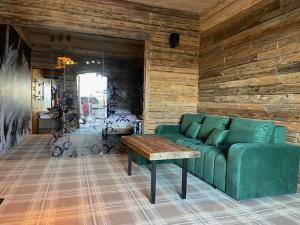 - un salon avec un canapé vert et une table dans l'établissement Ostoja Spokoju, à Olchowiec