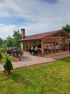 - un grand pavillon en bois avec une table de pique-nique et des tables dans l'établissement Căsuțele din Retezat, à Nucşoara