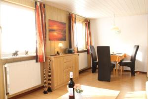 ein Esszimmer mit einem Tisch und einer Flasche Wein in der Unterkunft Haus Karin Ferienwohnung 1 in Büsum