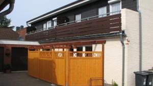 ein Gebäude mit orangefarbenen Türen und einem Balkon oben in der Unterkunft Haus Karin Ferienwohnung 1 in Büsum