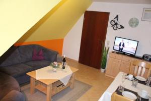 ein Wohnzimmer mit einem Sofa und einem TV in der Unterkunft Haus Lily Nr. 03 in Büsum