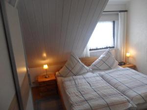 ein Schlafzimmer mit einem Bett mit zwei Lampen an Tischen in der Unterkunft Haus Lily Nr. 03 in Büsum