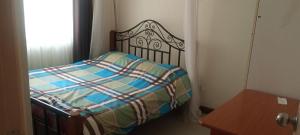 a bedroom with a bed and a table and a window at L'auberge Homestay in Nairobi