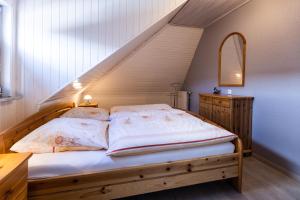 ein Schlafzimmer mit einem Bett mit einem Holzrahmen in der Unterkunft Haus Lily Nr. 04 in Büsum