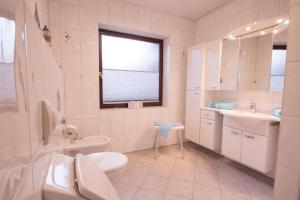 a white bathroom with a sink and a toilet at Haus Lily Nr.02 bis zu 6 Personen davon max. 2 Kinder in Büsum