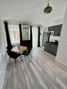 Una habitación con una mesa y sillas y una cocina. en Casa Macerata, en Turín
