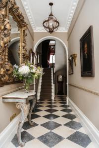 a hallway with a vase of flowers on a table at Henrys Townhouse Marylebone in London