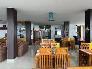 a restaurant with wooden tables and wooden chairs at HOTEL DEVDAR RESORT in Dharmsala