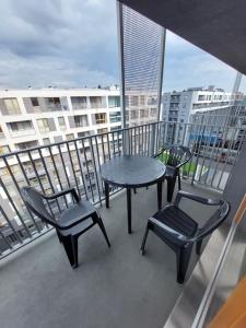 einen Balkon mit einem Tisch und Stühlen in der Unterkunft Schindler’s Factory Zabłocie Deluxe Apartments WAWELOFTS in Krakau