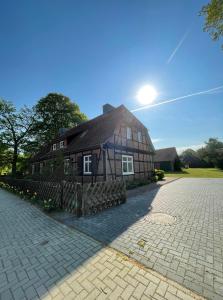 a large wooden house with a fence in front of it at Altes Waldarbeitergehöft in Munster