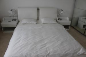 un grande letto bianco in una stanza con due lampade di Apartmán Relax so saunou a jakuzzi a Námestovo