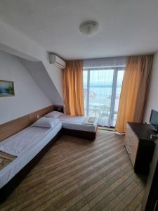 a hotel room with two beds and a balcony at Стаи за гости Мистрал in Primorsko +34 photos