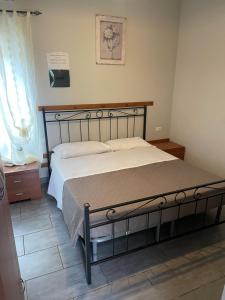 una camera con un grande letto con struttura in legno di Hotel La Torricella a Capalbio