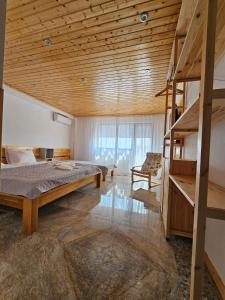 Casuta Noastra - Sulina في سولينا: غرفة نوم بسرير وسقف خشبي