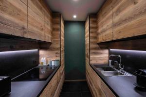 een keuken met houten wanden en een wastafel bij Cortina Center House in Cortina dʼAmpezzo