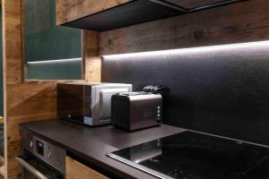 een keuken met een magnetron en een broodrooster op een aanrecht bij Cortina Center House in Cortina dʼAmpezzo +50 foto's