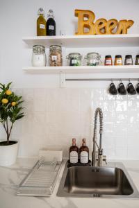 a kitchen sink with bottles of beer on a shelf at Redbrick’s Bergerac, Au coeur du centre historique in Bergerac