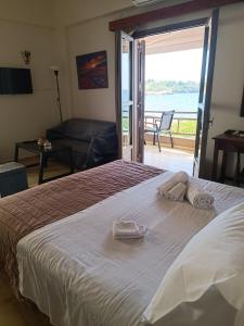 Schlafzimmer mit einem Bett und Meerblick in der Unterkunft Buganvilla Sea View apts in Agia Pelagia