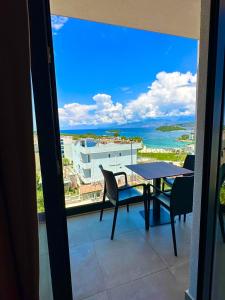balcón con mesa, sillas y vistas al océano en Hotel Ajden by Mira Mare, en Ksamil