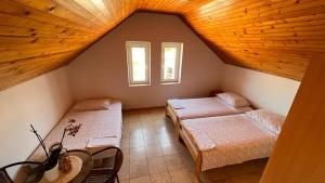 a attic room with two beds and two windows at Apartment 39 in Vir
