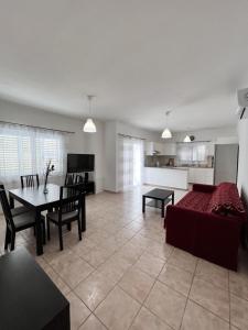 een grote woonkamer met een bank en een tafel bij Pafia Sunbeach Townhouse in Paphos City