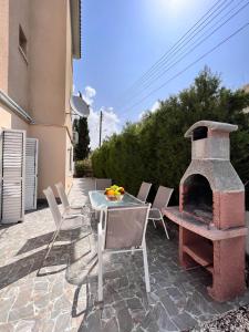 een patio met een tafel en een bakstenen oven bij Pafia Sunbeach Townhouse in Paphos City