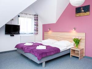 een slaapkamer met paarse muren en een groot bed bij Gościniec Ptasi Zaułek in Niechorze