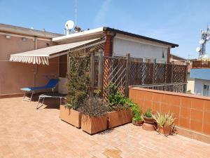 une terrasse avec un parasol et des plantes dans une maison dans l'établissement Attico Due Giugno, à Piombino