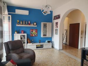 - un salon avec un canapé et un mur bleu dans l'établissement Attico Due Giugno, à Piombino