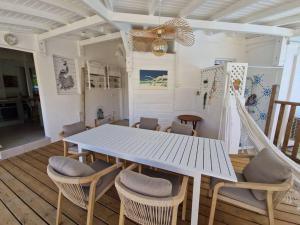 ein Esszimmer mit einem weißen Tisch und Stühlen in der Unterkunft Villa Eden, à 400 mètres de la plage du Souffleur in Port-Louis