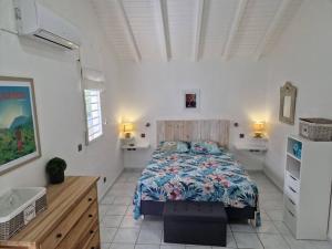 a bedroom with a bed in a white room at Villa Eden, à 400 mètres de la plage du Souffleur in Port-Louis