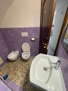 a purple bathroom with a toilet and a sink at StabiaSummer in Castellammare di Stabia +26 photos