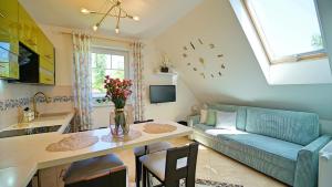 a kitchen and living room with a couch and a table at Apartamenty Every Sky Nad Łomnicą 1b-6b in Karpacz