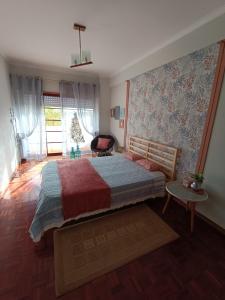 una camera da letto con un letto grande e una finestra di GREEN GARDEN APARTMENT IN ODIVELAS a Odivelas