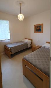 um quarto com 2 camas e um lustre em casa nel verde della Val di Vara em Serò