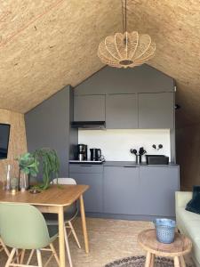 a living room with a table and a kitchen at EuroParcs De Wiedense Meren in Wanneperveen