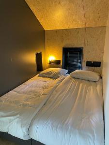 a large white bed sitting in a bedroom at EuroParcs De Wiedense Meren in Wanneperveen