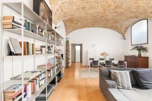 a living room with a large book shelf filled with books at Casa Doria by Burghesius in Rome