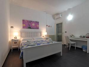 1 dormitorio con 1 cama, mesa y sillas en B&B The Sun 'tis, en Castro di Lecce